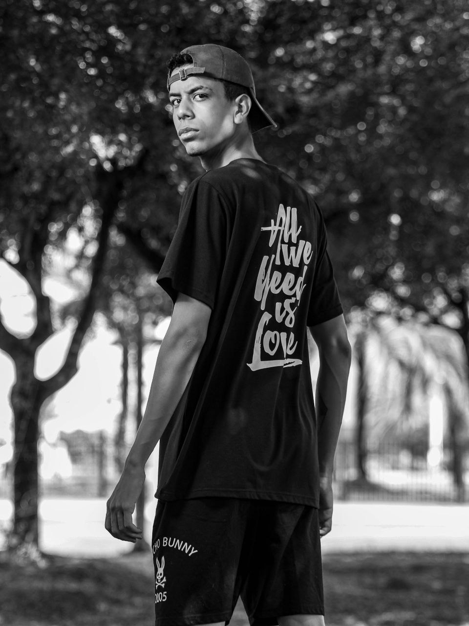 Homem negro com moletom bege mexendo no celular e sorrindo